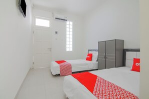 A hotel room with two beds, a wardrobe, a door, and a window. - Capital O 90342 Kemang Garden (Jakarta)