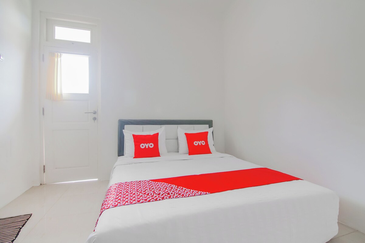 Una habitación de hotel con una cama, una puerta y una ventana.