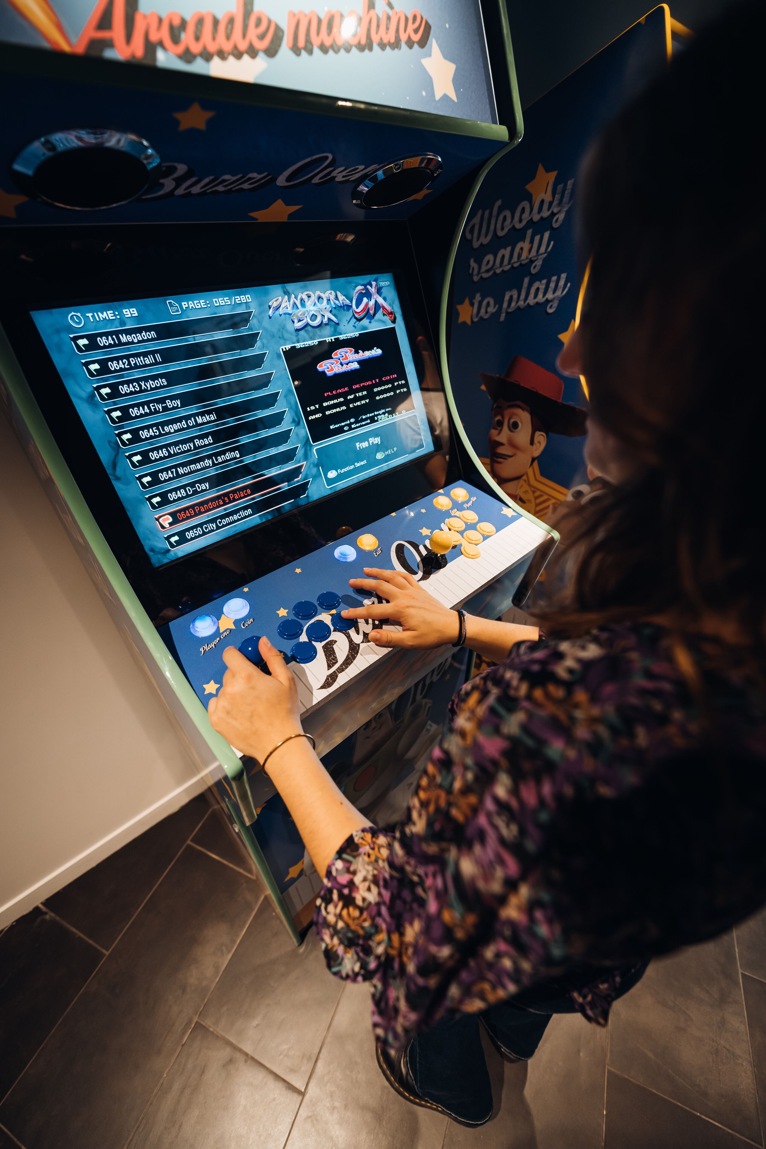 Una persona jugando un videojuego en una consola, con una pantalla que muestra opciones de juego y una interfaz colorida.
