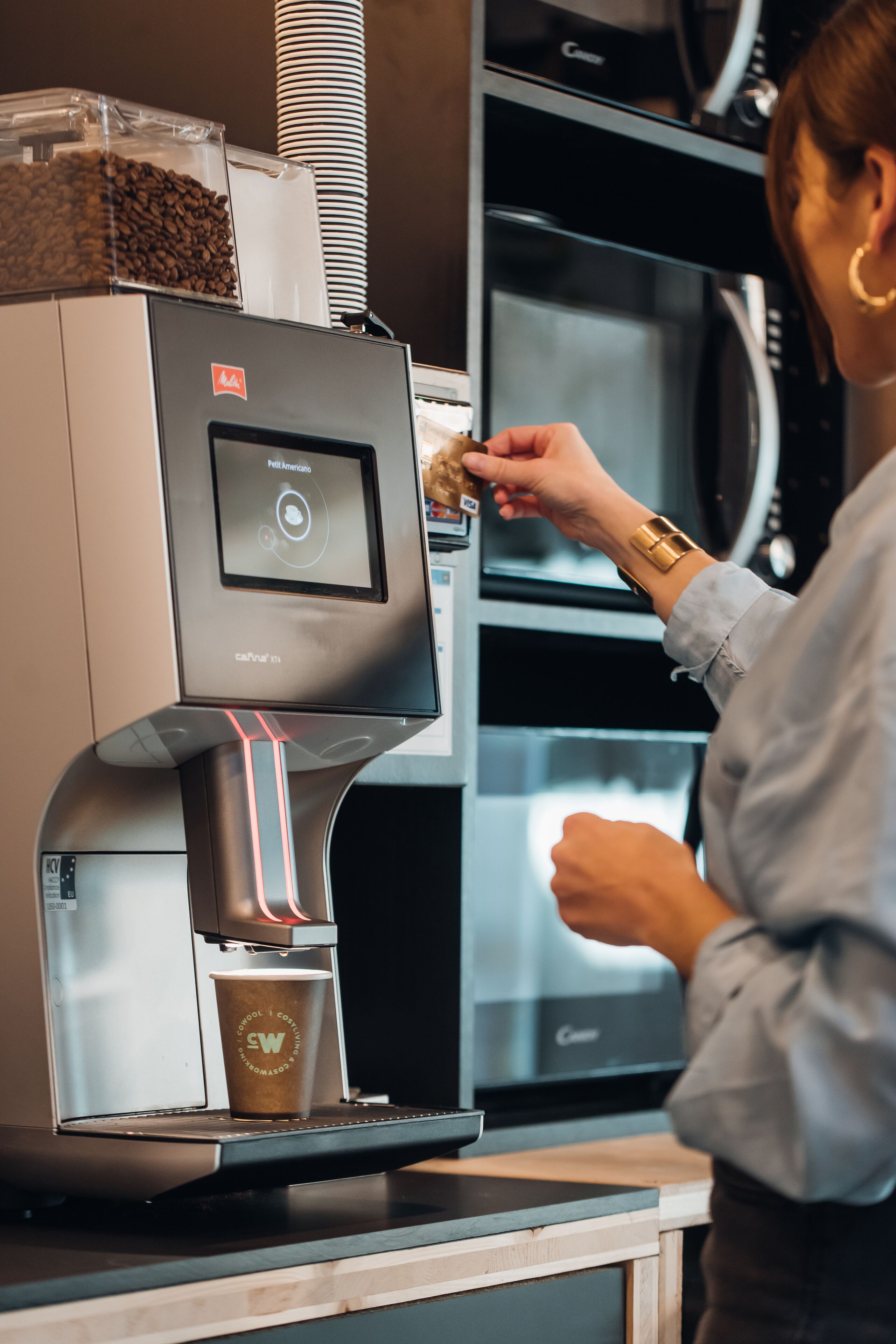 A coffee machine with a digital interface and a cup placed underneath.