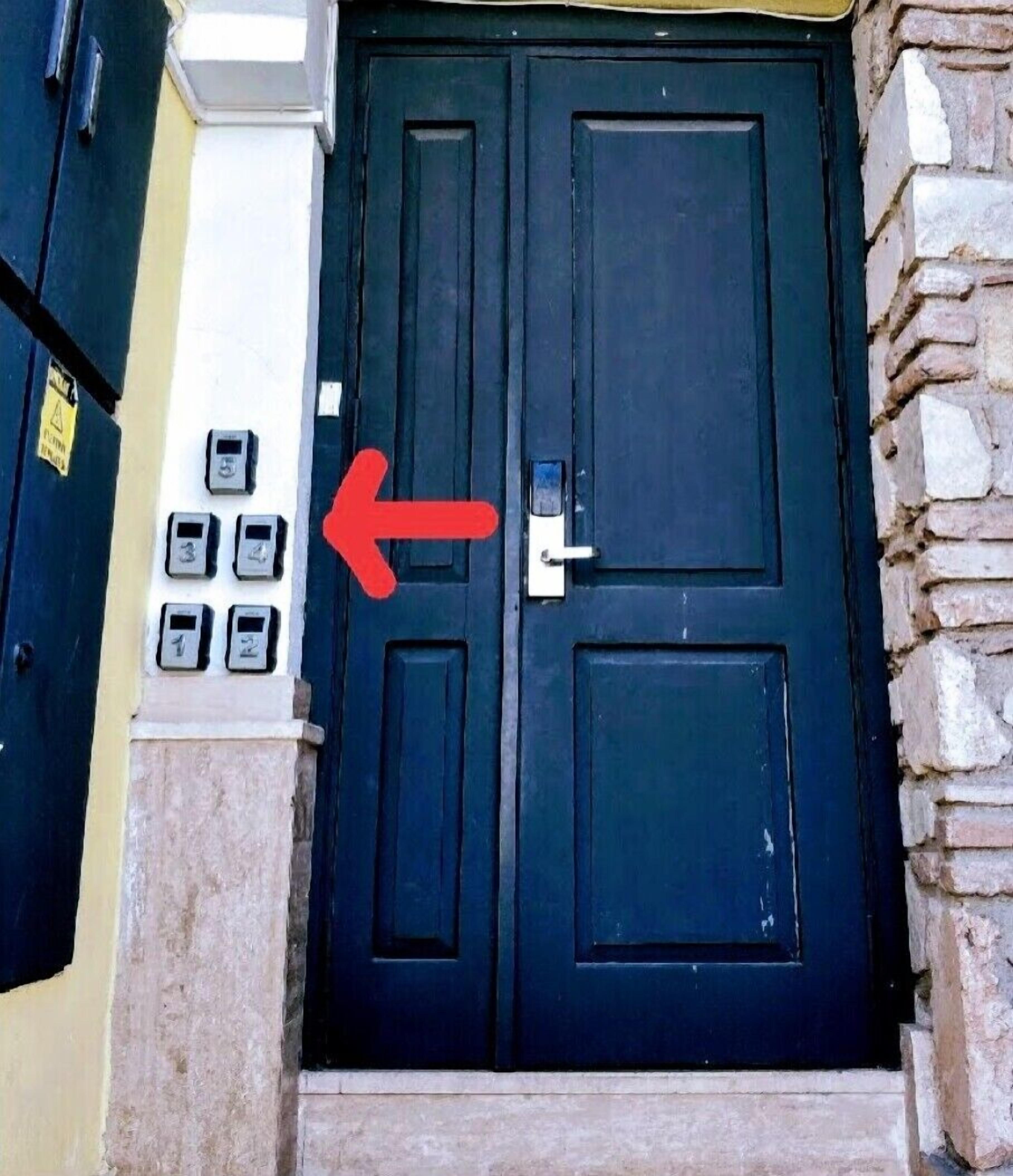 A dark blue door with a keypad lock and a red arrow pointing to it.