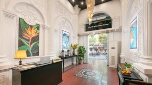 A hotel lobby with a reception desk, a chandelier, and a sign that reads 'Home away from home'. - Hanoi Posh Hotel (Hanoi)