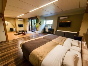 Une chambre d’hôtel moderne avec un grand lit, un bureau, une chaise, une télévision et une plante en pot.