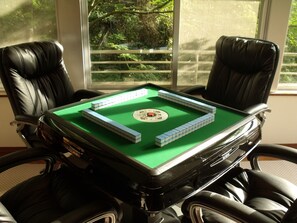 A pool table with tiles and a cue ball, surrounded by black leather chairs. - Livemax Resort Amagi Yugashima (Izu)
