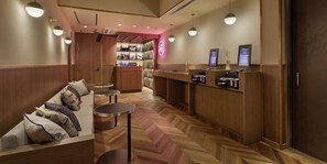 A hotel lobby with a reception desk, seating area, and a display of items on the wall. - Hotel The Hakata Terrace Fukuoka (Fukuoka)