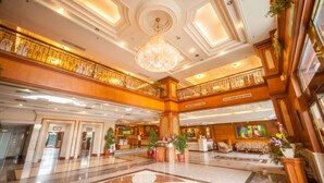 A spacious lobby with a grand chandelier, a reception desk, and a seating area with sofas. - Cheng Pao Hotel (Puli)