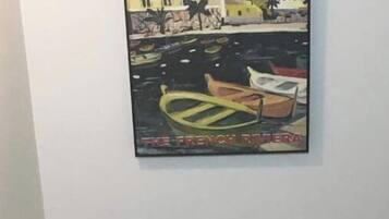 Un tableau représentant un port avec des bateaux et des bâtiments.