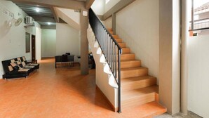 A spacious living area with a staircase, a sofa, and a dining table.