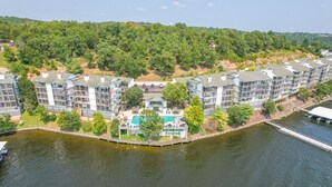 A waterfront residential complex with multiple apartment buildings, a dock, and a sign reading "Harbour Town." - HT901 - Impressive lakefront condo! (Lake Ozark)