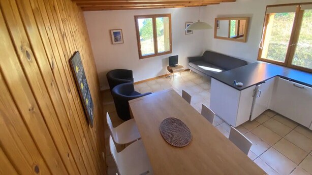 Une cuisine compacte comprenant une table à manger, des chaises, un petit îlot et un banc intégré.