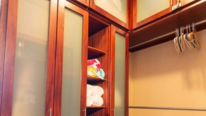 Un meuble en bois avec des portes en verre dépoli, un sol carrelé de carreaux blancs et un luminaire fixé au mur.