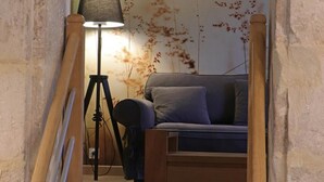 A cozy room with a wooden bed, a floor lamp, and a tripod.