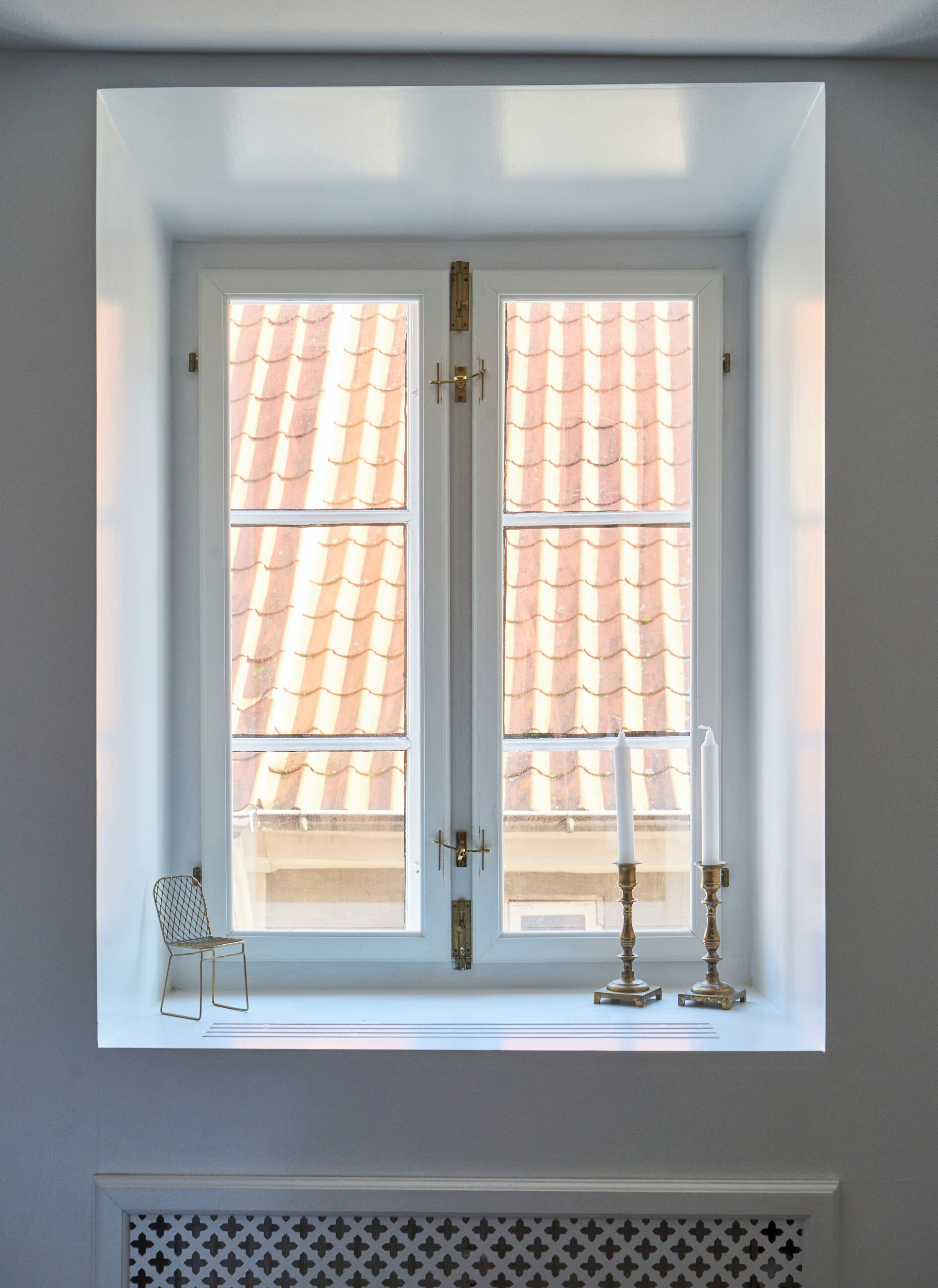 A window with a white frame, two glass panes, and a metal latch.