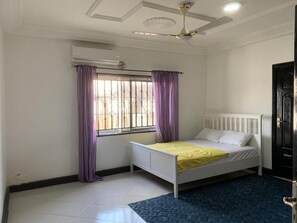 Cozy retreat with a comfortable bed, window, and ceiling fan.
