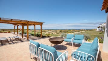 Una piscina al aire libre, sombrillas, sillones reclinables de piscina