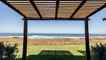 Una pérgola de madera con vista al océano.