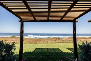 A wooden pergola with a view of the ocean.