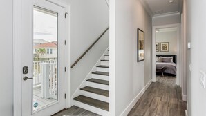 A hallway with a staircase leading to a bedroom. - Luxury Gulf View Home with Private Pool! Steps to the beach! (Pensacola Beach)