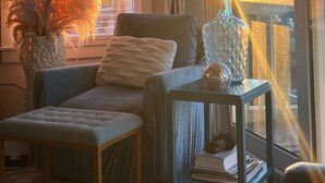 A cozy living room with a sofa, a side table with a lamp, and a large window with blinds. - 30A condo. Private beach. Incredible view! (Seacrest)