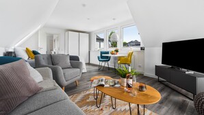 Un moderno loft con zona living, angolo pranzo e angolo cottura.