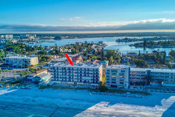 An aerial view of Kima, a coastal hotel with multiple buildings, a beach, and a marina. - **DIRECT BEACH FRONT**GREAT LOCATION** 2 BEDROOM 2 BATH**AWESOME VIEWS** (Madeira Beach)