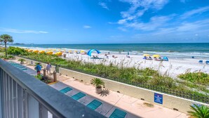 A beach view from a balcony with a pool, umbrellas, and a clear sky. - **DIRECT BEACH FRONT**GREAT LOCATION** 2 BEDROOM 2 BATH**AWESOME VIEWS** (Madeira Beach)