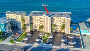 A hotel with a parking lot and a view of the ocean. - **DIRECT BEACH FRONT**GREAT LOCATION** 2 BEDROOM 2 BATH**AWESOME VIEWS** (Madeira Beach)