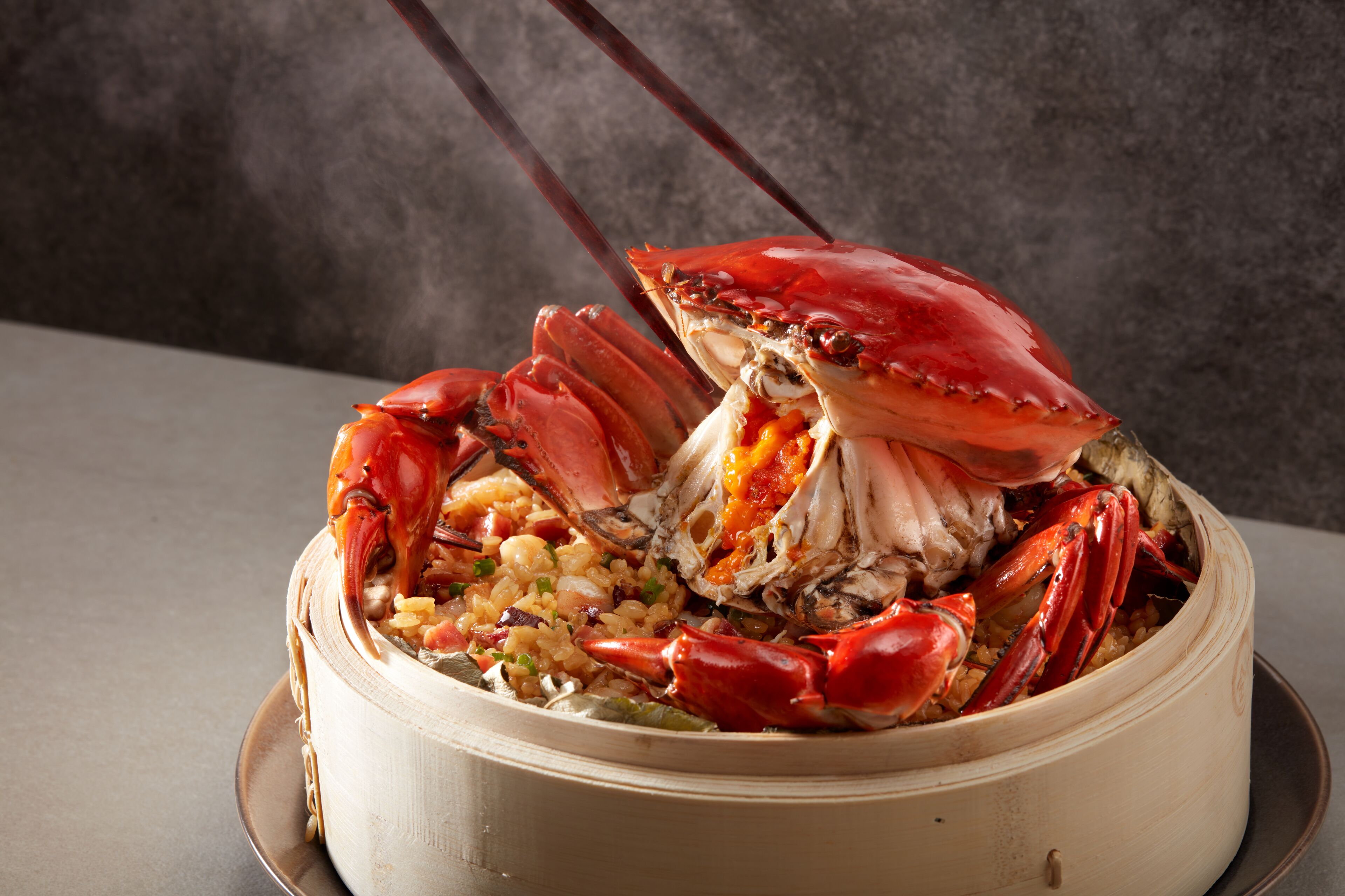 Una olla grande con un cangrejo entero y arroz.