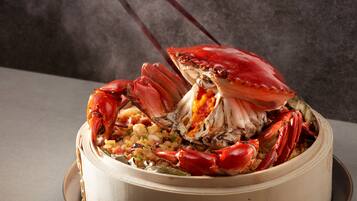 Una olla grande con un cangrejo entero y arroz.