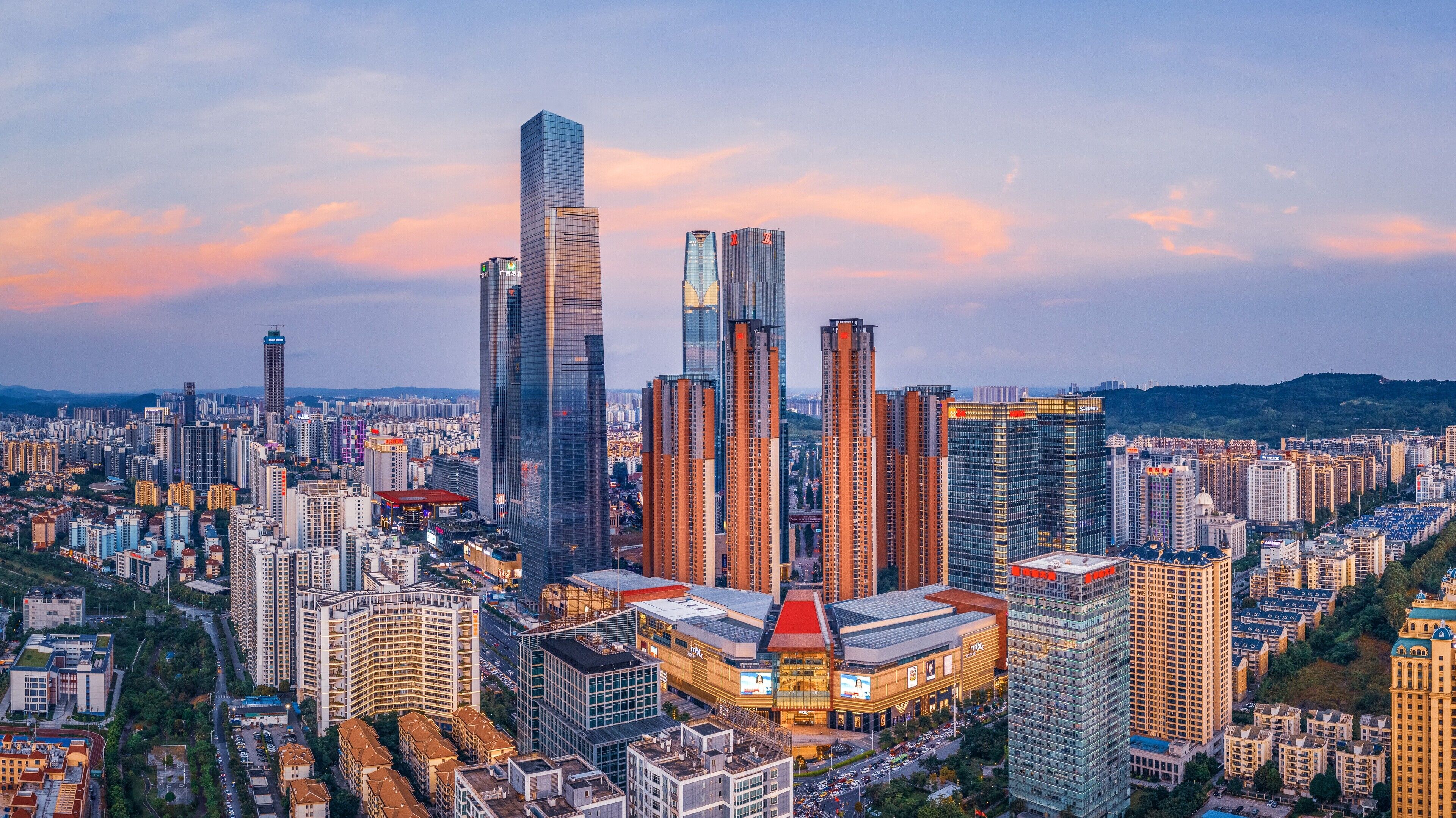 A cityscape with high-rise buildings, including a prominent skyscraper and several shorter buildings.