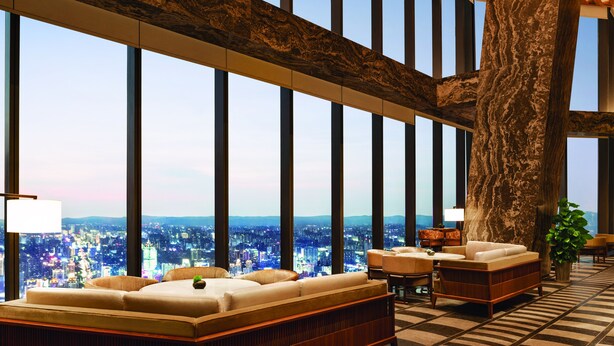 A spacious lobby with a large tree trunk, high ceilings, and a city view through floor-to-ceiling windows. - Shangri-La Nanning (Nanning)