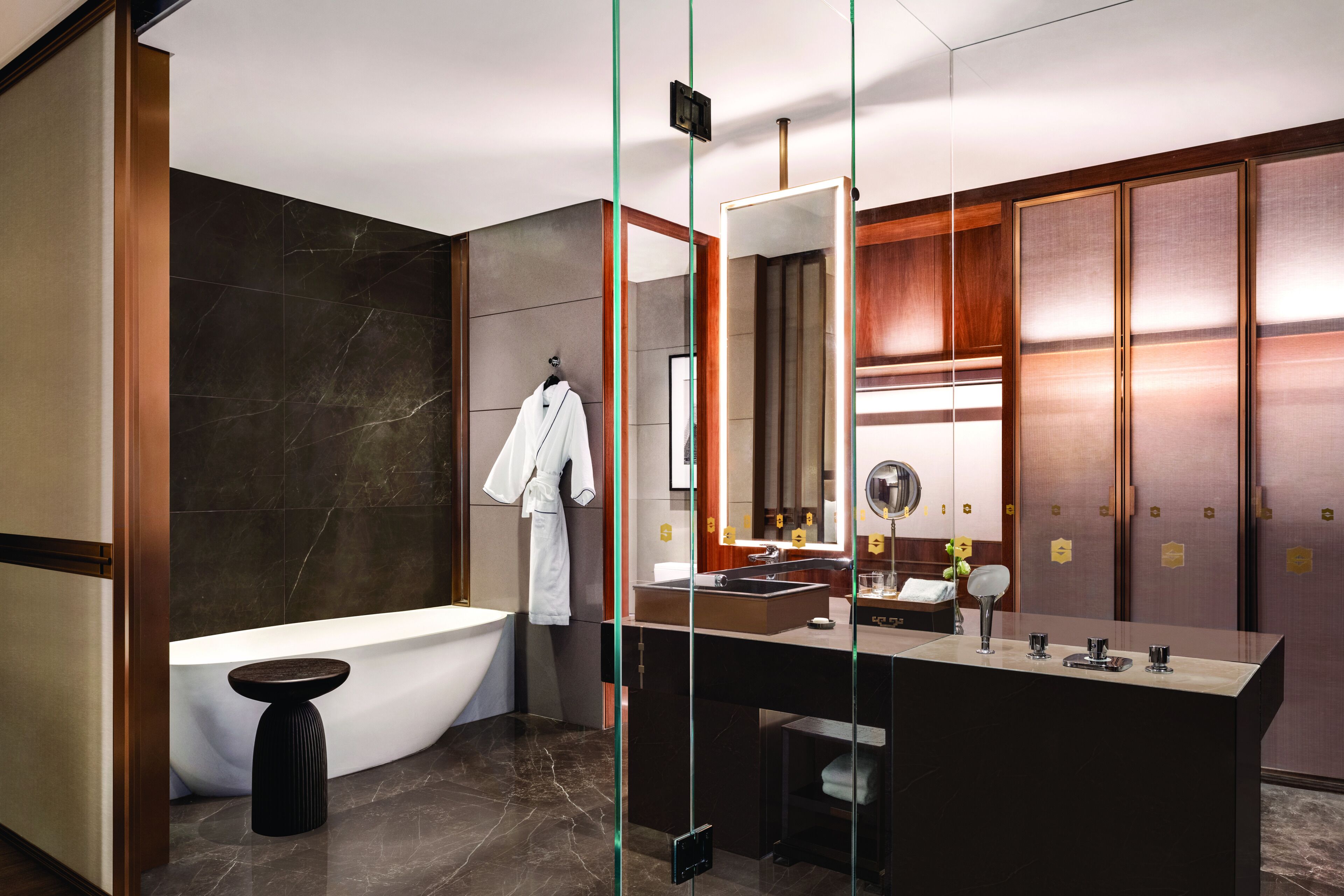 A modern bathroom with a freestanding bathtub, a large mirror, and a vanity with a sink and countertop.