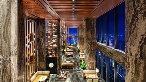 A modern hotel lobby with a checkered floor, seating areas, and a city view through large windows. - Shangri-La Nanning (Nanning)
