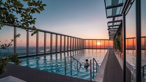 A rooftop infinity pool with a cityscape view at sunset. - Shangri-La Nanning (Nanning)