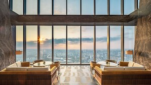 A modern hotel lobby with large floor-to-ceiling windows, a central seating area with sofas and tables, and a patterned floor. - Shangri-La Nanning (Nanning)