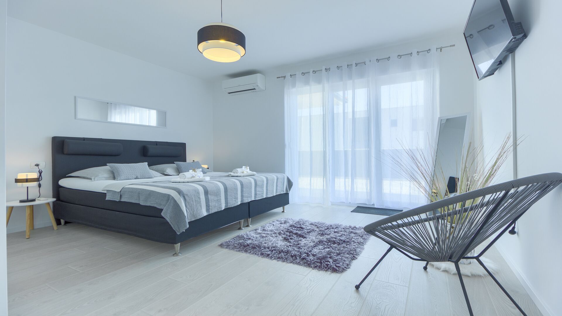 A modern bedroom with a bed, bedside table, and a chair.