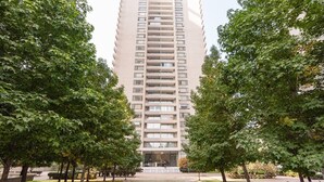 A tall, modern apartment building with a central entrance and a symmetrical design. - Arauco Wood - 2BR, Parking, Wifi, Mall & Pool (Vitacura)