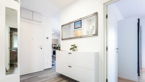 A hallway with a white wardrobe, a mirror, and a potted plant. - Luxury Modern Penthouse w Jacuzzi & Huge Terrace (Split)