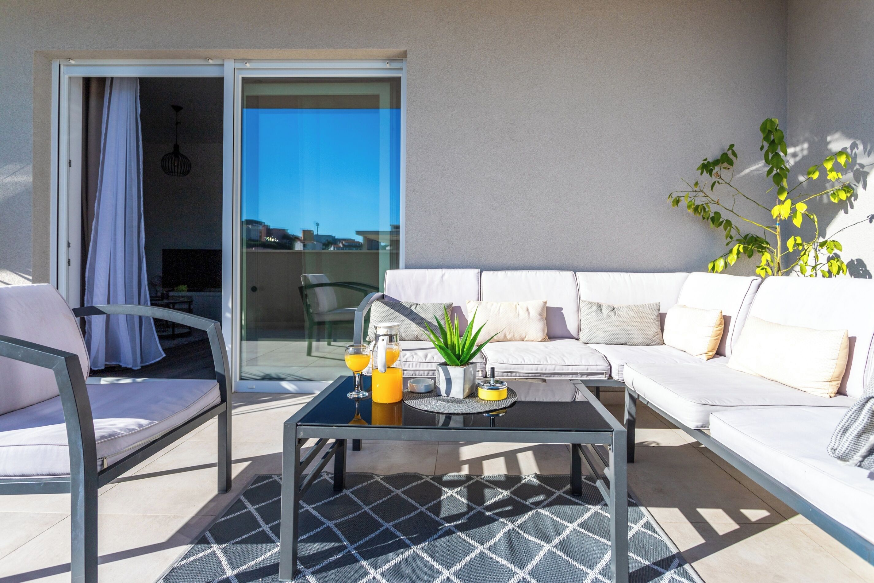 A modern outdoor seating area with a sofa, chairs, and a coffee table.