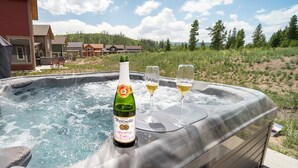 Ein Whirlpool mit einer Flasche Martini Sparkling Cider und zwei Weingläsern.