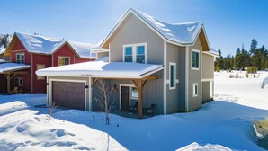 Ein Wohngebiet mit schneebedeckten Häusern, einschließlich Garage und überdachter Veranda.