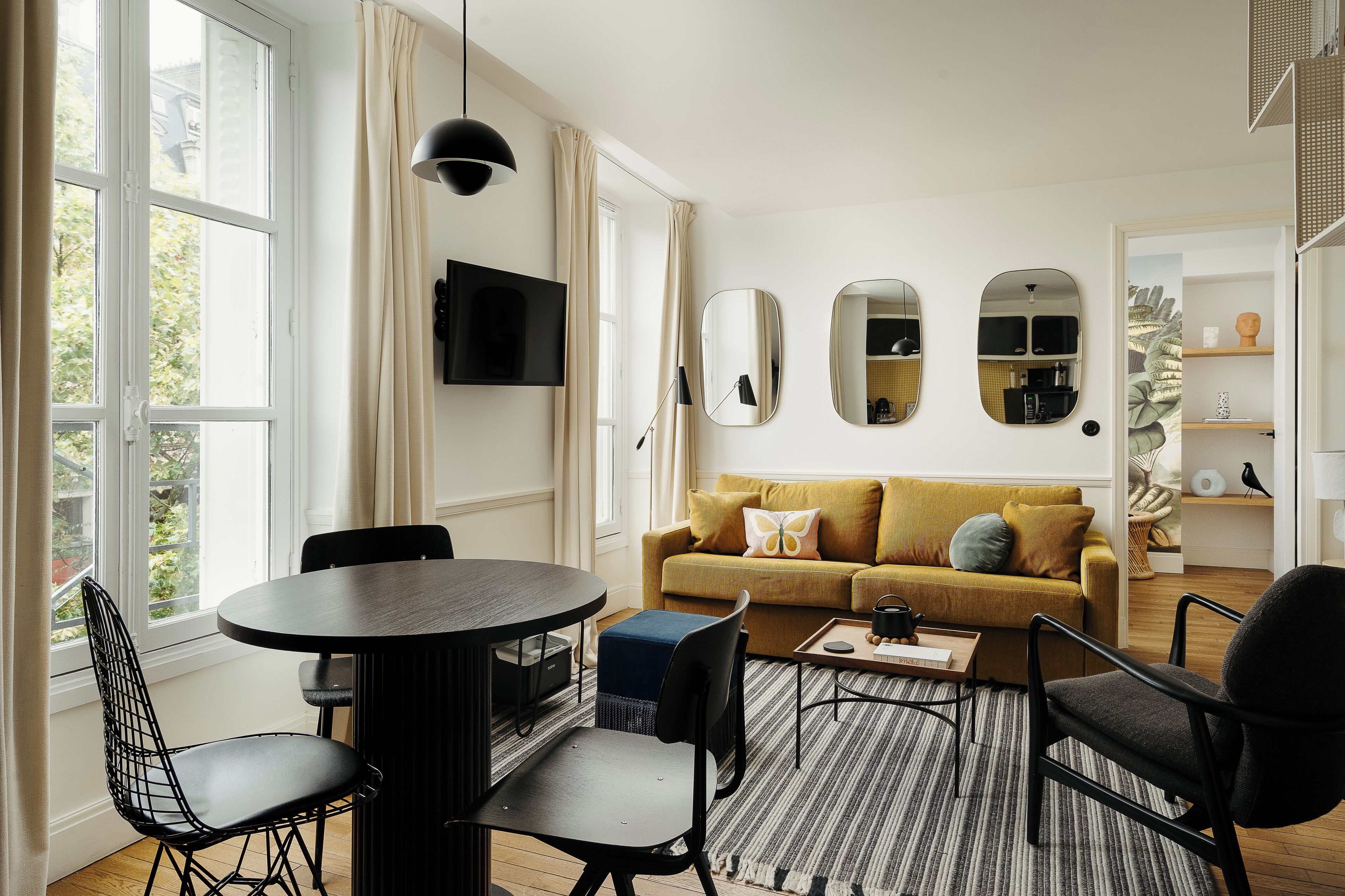 Un salon moderne avec un canapé, des fauteuils, une table basse et un téléviseur.