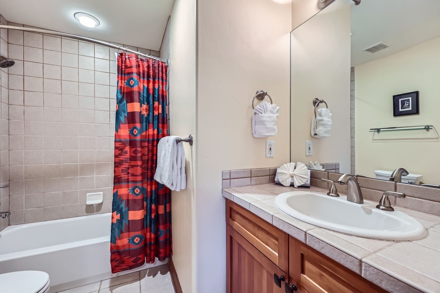 A bathroom with a shower, a sink, and a toilet.