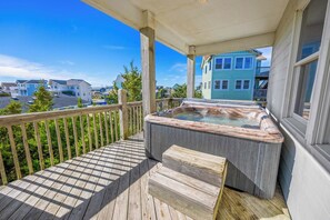 A wooden deck with a hot tub and steps leading to a covered porch. - Oceanfront Dog Friendly Home in Avon w/ Elevator, Hot Tub, Game Room, Wet Bar (Avon)
