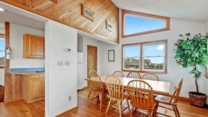 Una cocina amplia con armarios de madera y un comedor con una mesa grande y sillas.