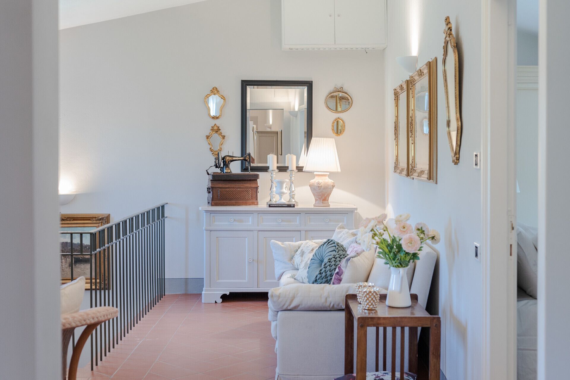 A hallway with a white console table, a mirror, and a lamp.