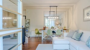A modern living room with a white sofa, a dining area with a table and chairs, and a kitchen visible through an open door. - A Seaside Sanctuary in the Heart of Viareggio (Viareggio)
