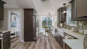 Una cocina moderna con armarios de madera oscura, una isla grande y vistas al exterior.