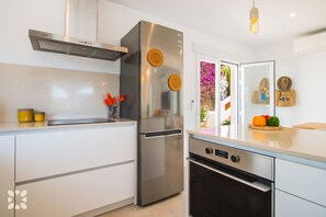 Een moderne keuken met roestvrijstalen apparatuur, een inbouwoven en een wit aanrecht.