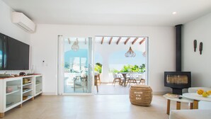 Una sala de estar moderna con televisor, sofá y chimenea.